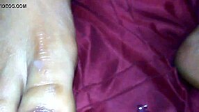 An ebony woman gives a footjob, leading to a cumshot on her feet.