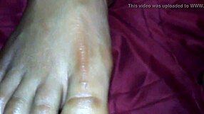 An ebony woman gives a footjob, leading to a cumshot on her feet.