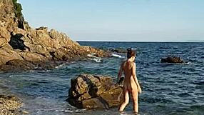 She walks naked on the public beach, inserting pebbles into her pussy.