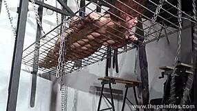 redhead amateur slavegirl in metal bondage lowered over burning candles