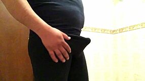 Cross gay trying on leggings in suggestive pose