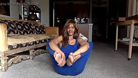 Ginger Mistress teases in blue, nipples exposed, smiles while licking herself