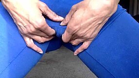 Ginger Mistress teases in blue, nipples exposed, smiles while licking herself