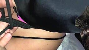 Masked figure bound tightly while performing deep blowjob on hard cock.