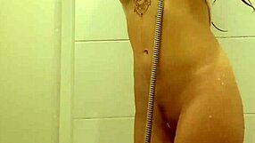 Redhead teen with tattoos takes a steamy bath, showing off her body in the shower.