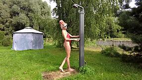 hey, check out this tall sexy girl flashing her shaved legs in a mesh pink monokini out in the garden nature