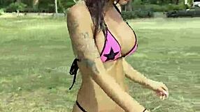 Monika Fox poses solo in pink bikini with stars on the beach showing big fake tits free