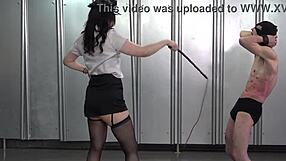 Japanese femdom guard whips and dominates two masochistic male prisoners in prison cell