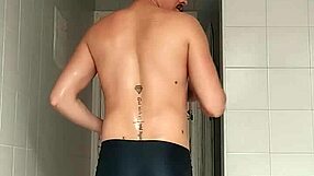 a sexy guy slips into the bathroom at the beach pulls down his black shorts and carefully shaves his smooth body